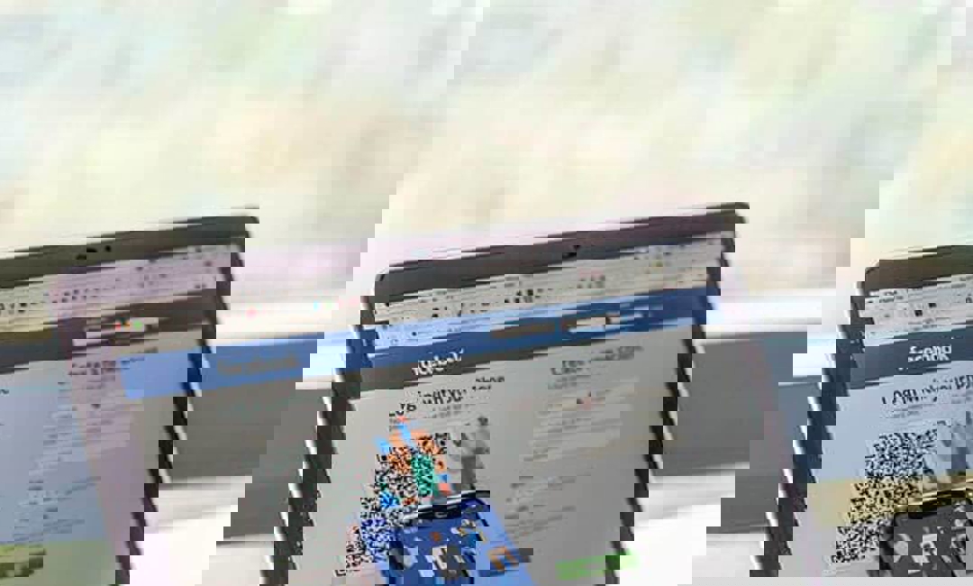 image of mobile device being held next to laptop