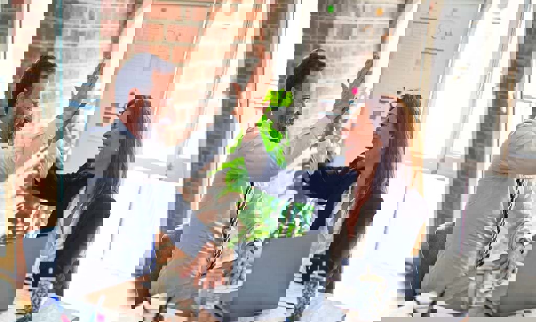 Two business people high five in an office setting