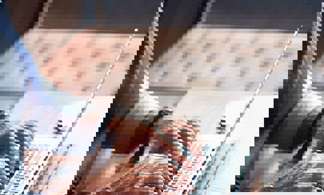 man typing on laptop