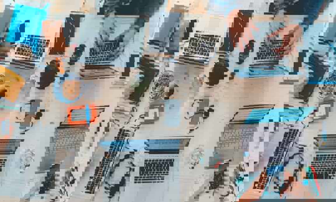 Image of a table with laptops and work stations