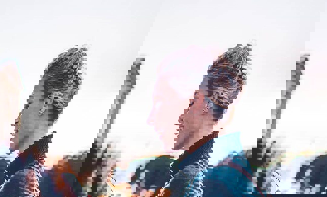 image of woman smiling while on mobile phone