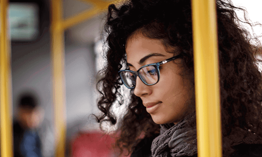 Ethnic woman looking at her phone on the subway