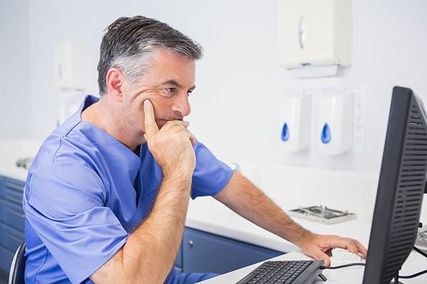 A displeased dentist looking online.